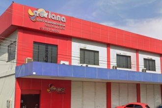 Fachada da distribuidora Adriane, com letreiro e cores vibrantes.