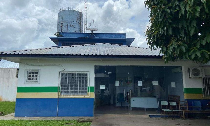 Fachada de delegacia da Polícia Civil do Amazonas, com céu nublado ao fundo.