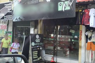 Fachada de loja 'Martin Cell' com letreiro e pessoas na rua.