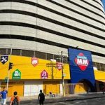 Fachada do Atacadão MM com estrutura imponente e anúncios de recrutamento.