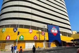 Fachada do Atacadão MM com estrutura imponente e anúncios de recrutamento.