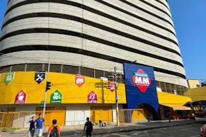 Fachada do Atacadão MM com estrutura imponente e anúncios de recrutamento.
