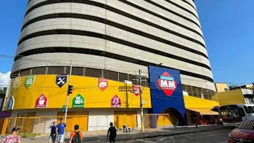 Fachada do Atacadão MM com estrutura imponente e anúncios de recrutamento.