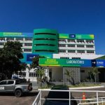 Fachada do Complexo Hospitalar Sul no Amazonas, com veículos estacionados e céu azul