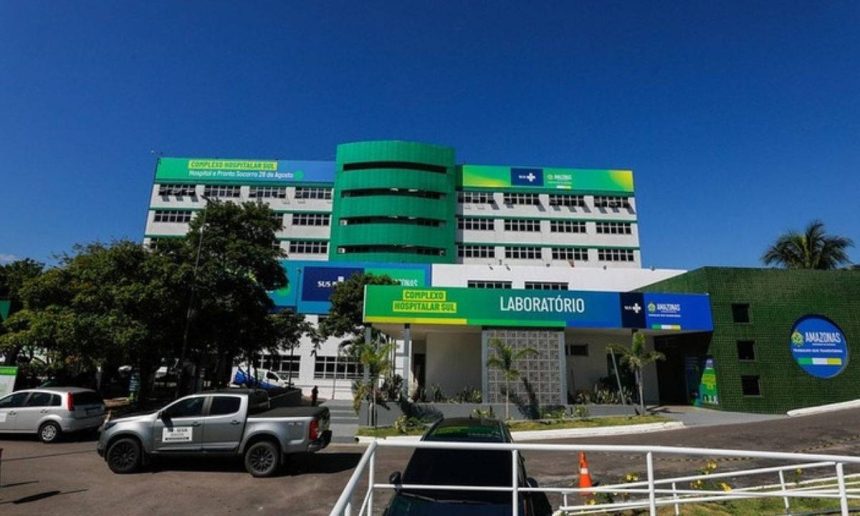 Fachada do Complexo Hospitalar Sul no Amazonas, com veículos estacionados e céu azul