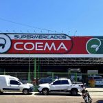 Fachada do Supermercados Coema com veículos estacionados.
