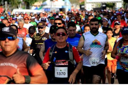 Grande número de pessoas correndo em uma maratona, com destaque para atletas com números de identificação.