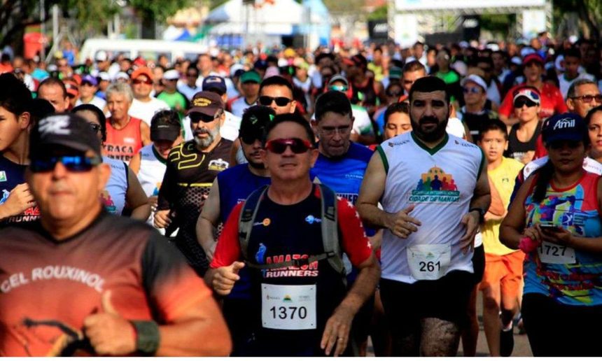 Grande número de pessoas correndo em uma maratona, com destaque para atletas com números de identificação.