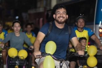 Grupo de ciclistas em evento do Pedala Livre em Manaus, com balões amarelos.