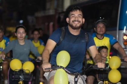 Grupo de ciclistas em evento do Pedala Livre em Manaus, com balões amarelos.