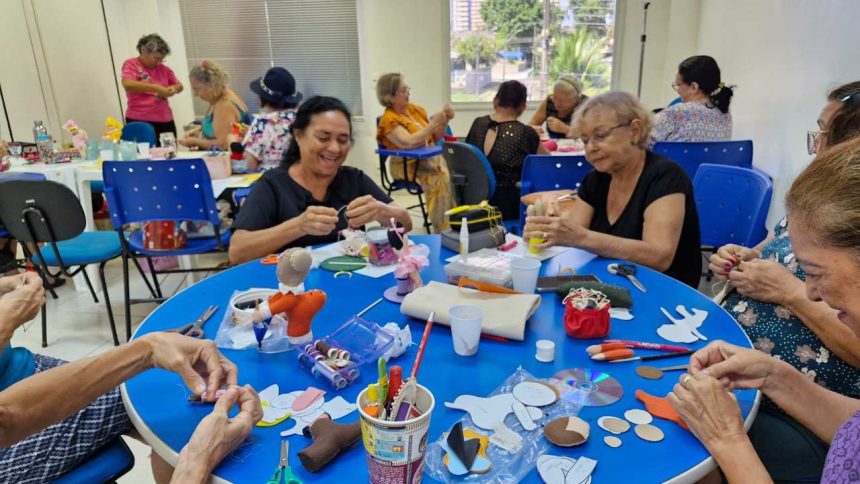 Grupo de mulheres em curso de artesanato, focadas em costura criativa, com materiais e projetos sobre a mesa.