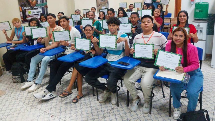 Grupo de pessoas sorrindo e segurando certificados após a conclusão de um curso.