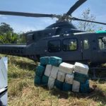 Helicóptero da Polícia Federal apreendido com drogas, com uma aeronave menor avariada em um lago