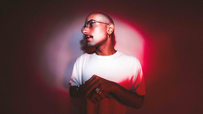 Homem com óculos e camisa branca em luz vermelha