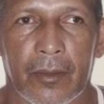 Homem idoso, pele morena, olhando para a câmera, possivelmente em busca de identificação.