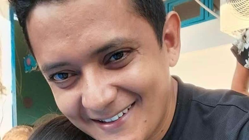 Homem sorrindo, possivelmente em contexto de denúncia de violência.