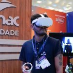 Homem usando óculos de realidade virtual em evento da Senac, Feira Norte do Estudante.