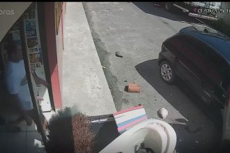 Idosa é prensada entre veÃculos em acidente de trânsito, registrado por câmera de segurança.