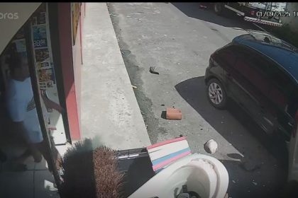 Idosa é prensada entre veículos em acidente de trânsito, registrado por câmera de segurança.