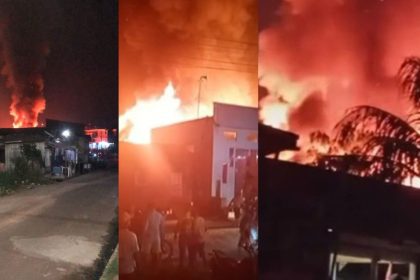 Incêndio de grandes proporções atinge residências e igreja à noite, com chamas e fumaça visíveis.