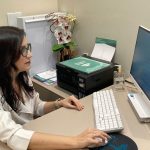 Médica em consultório, preparando-se para atender e discutir a importância dos cuidadores no Alzheimer.