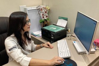 Médica em consultório, preparando-se para atender e discutir a importância dos cuidadores no Alzheimer.