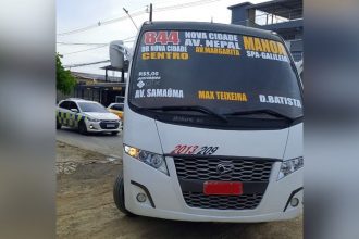 Micro-ônibus apreendido em operação de fiscalização, mostrando detalhes da rota e informações.