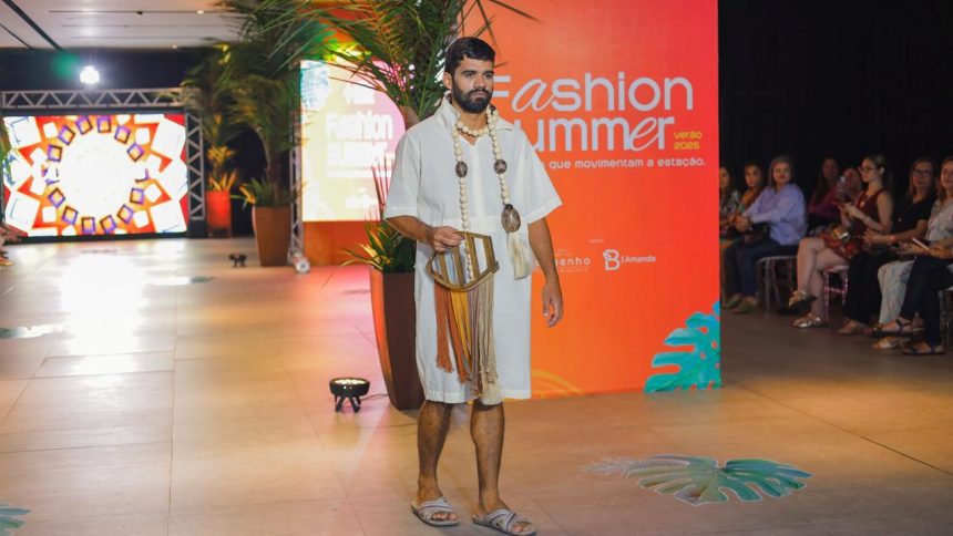 Modelo em desfile de moda, vestindo roupa clara e acessórios, em evento Fashion Summer.