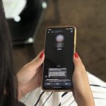Mulher segurando celular com alerta da Polícia Civil sobre golpes virtuais.