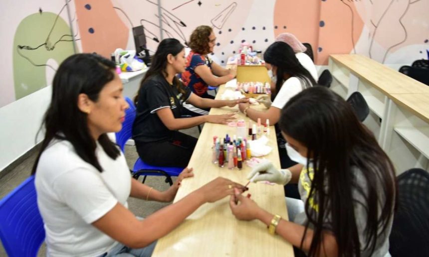 Mulheres em curso de manicure no Cetam, aprendendo e aplicando esmalte nas unhas.