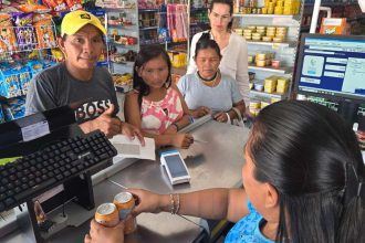 Mutirão da CAIXA em Santa Isabel do Rio Negro: atendimento no caixa de supermercado.