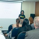 Palestrante em evento de Direito BancÔrio em Manaus, com tela do Google ao fundo e público atento.