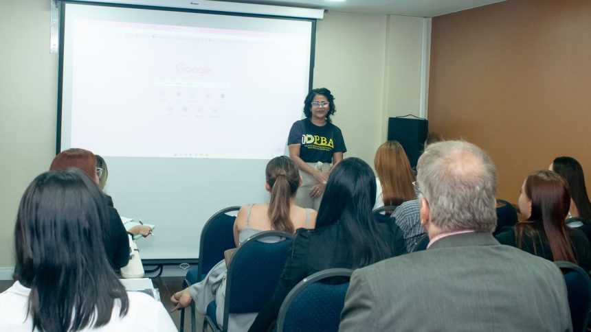 Palestrante em evento de Direito Bancário em Manaus, com tela do Google ao fundo e público atento.