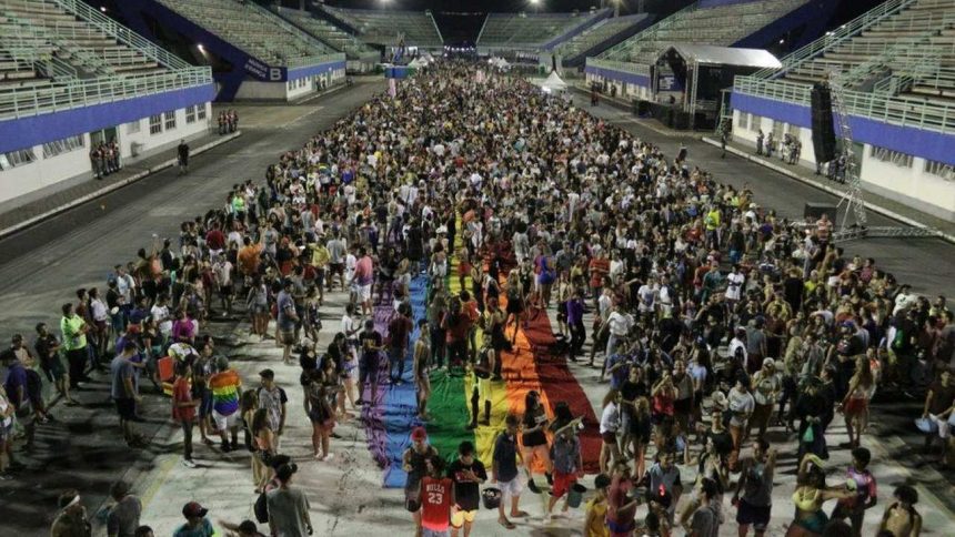 Parada do Orgulho LGBT+ em Manaus com multidão e bandeira arco-íris.