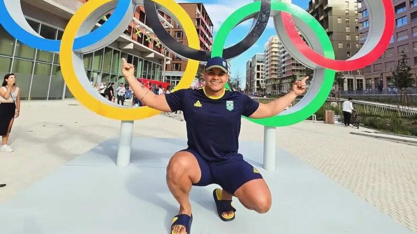 Pedro Nunes posa em frente aos anéis olímpicos, comemorando convocação.
