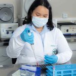 Pesquisadora do Hemoam e UEA trabalhando em laboratório, utilizando equipamento.