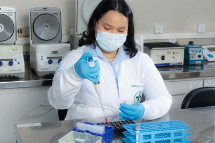 Pesquisadora do Hemoam e UEA trabalhando em laboratório, utilizando equipamento.