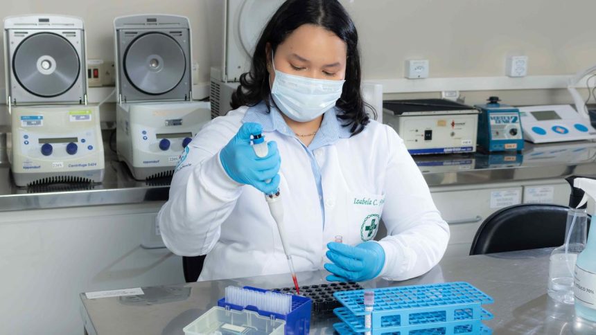 Pesquisadora do Hemoam e UEA trabalhando em laboratório, utilizando equipamento.