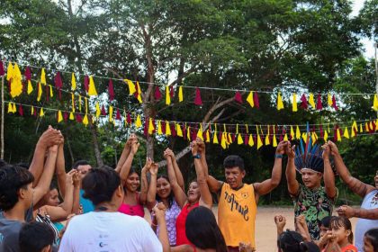 Pessoas de mãos dadas em celebração com decoração festiva ao fundo