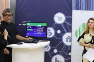 Pessoas em evento com tela mostrando dados de sorteio, incluindo nomes e valores.