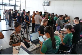 Pessoas em fila e atendentes em evento da Afeam (Agência de Fomento do Amazonas).