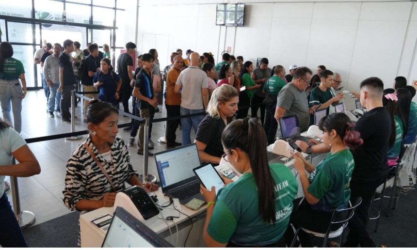 Pessoas em fila e atendentes em evento da Afeam (Agência de Fomento do Amazonas).