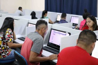 Pessoas fazendo prova eletrônica em computadores, em sala de aula, Provão EJA Amazonas