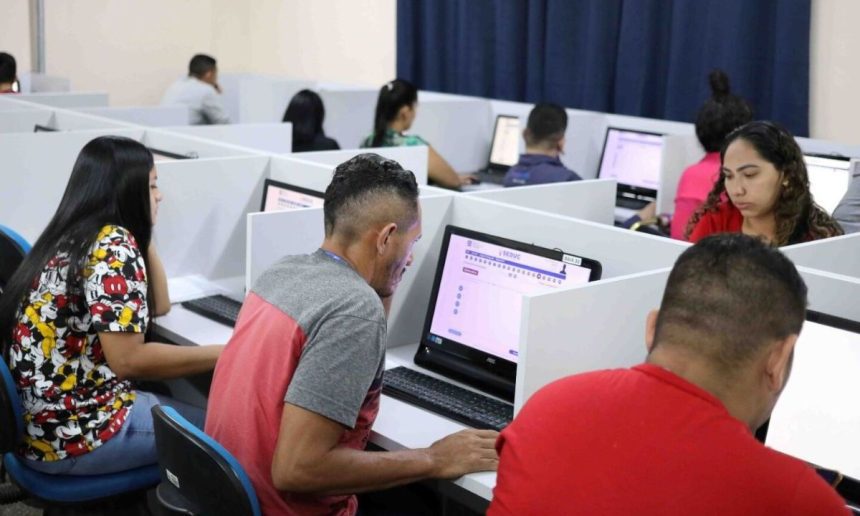 Pessoas fazendo prova eletrônica em computadores, em sala de aula, Provão EJA Amazonas