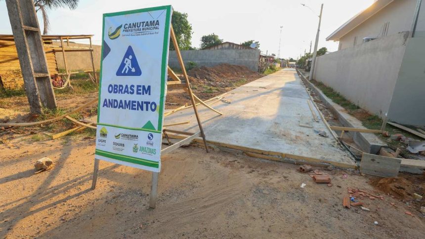 Placa 'Obras em andamento' em rua em construção em Canutama, Amazonas.