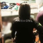 Policial com camisa preta com a escrita 'Polícia Civil' em uma investigação.