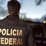 Policial federal com colete da Polícia Federal em operação.