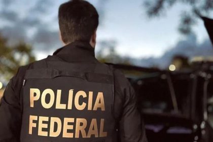 Policial federal com colete da Polícia Federal em operação.