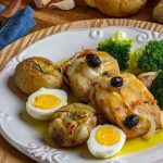 Prato de bacalhau com batatas, brócolis, ovos e azeitonas, em evento gastronômico.