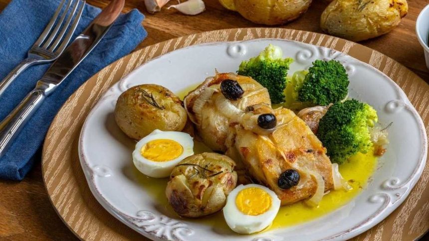 Prato de bacalhau com batatas, brócolis, ovos e azeitonas, em evento gastronômico.